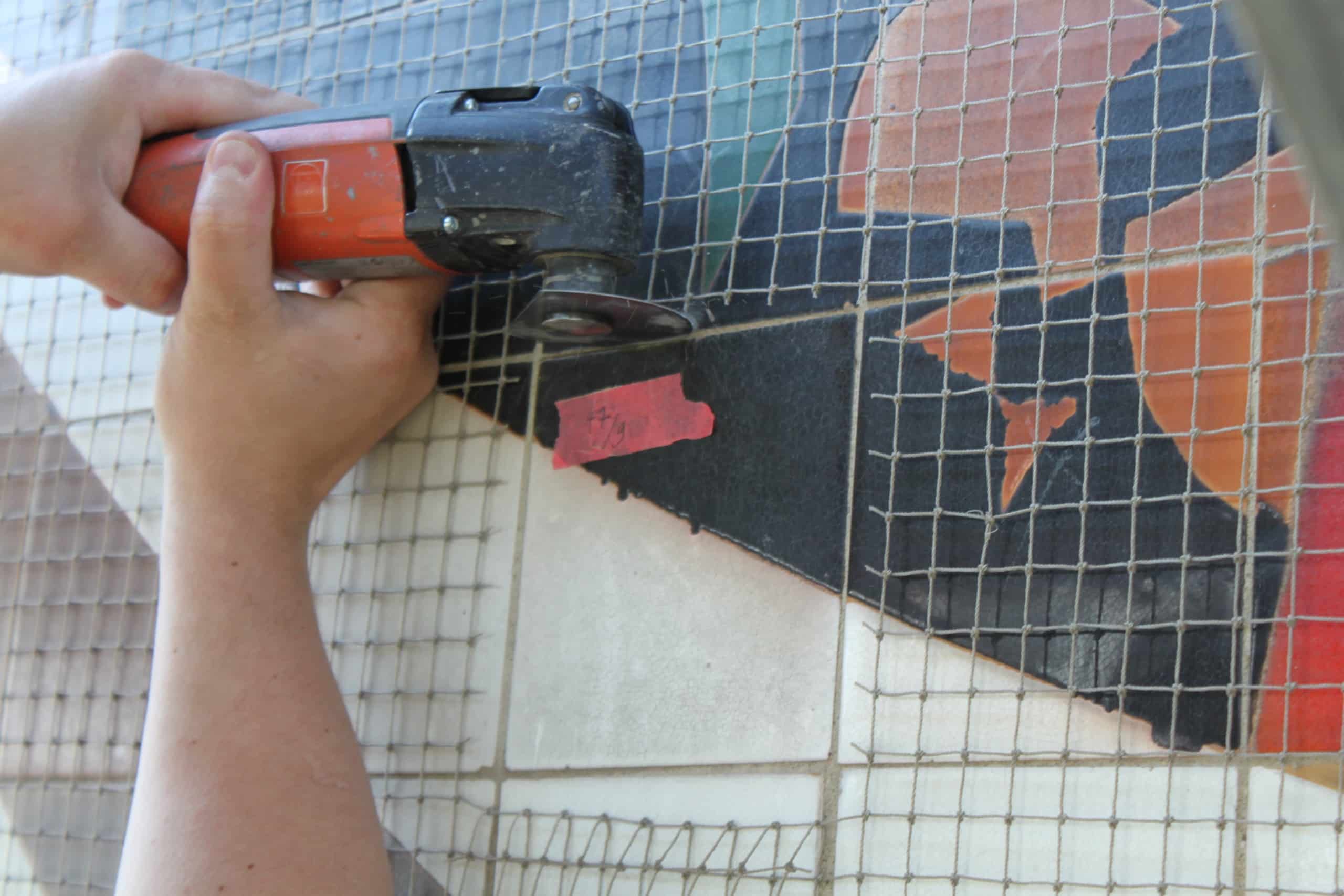 Restaurierungsarbeiten: Herausschneiden einer hohlliegenden Fliese, Foto: Gustav van Treeck GmbH / Programm „Baubezogene Kunst in der DDR“