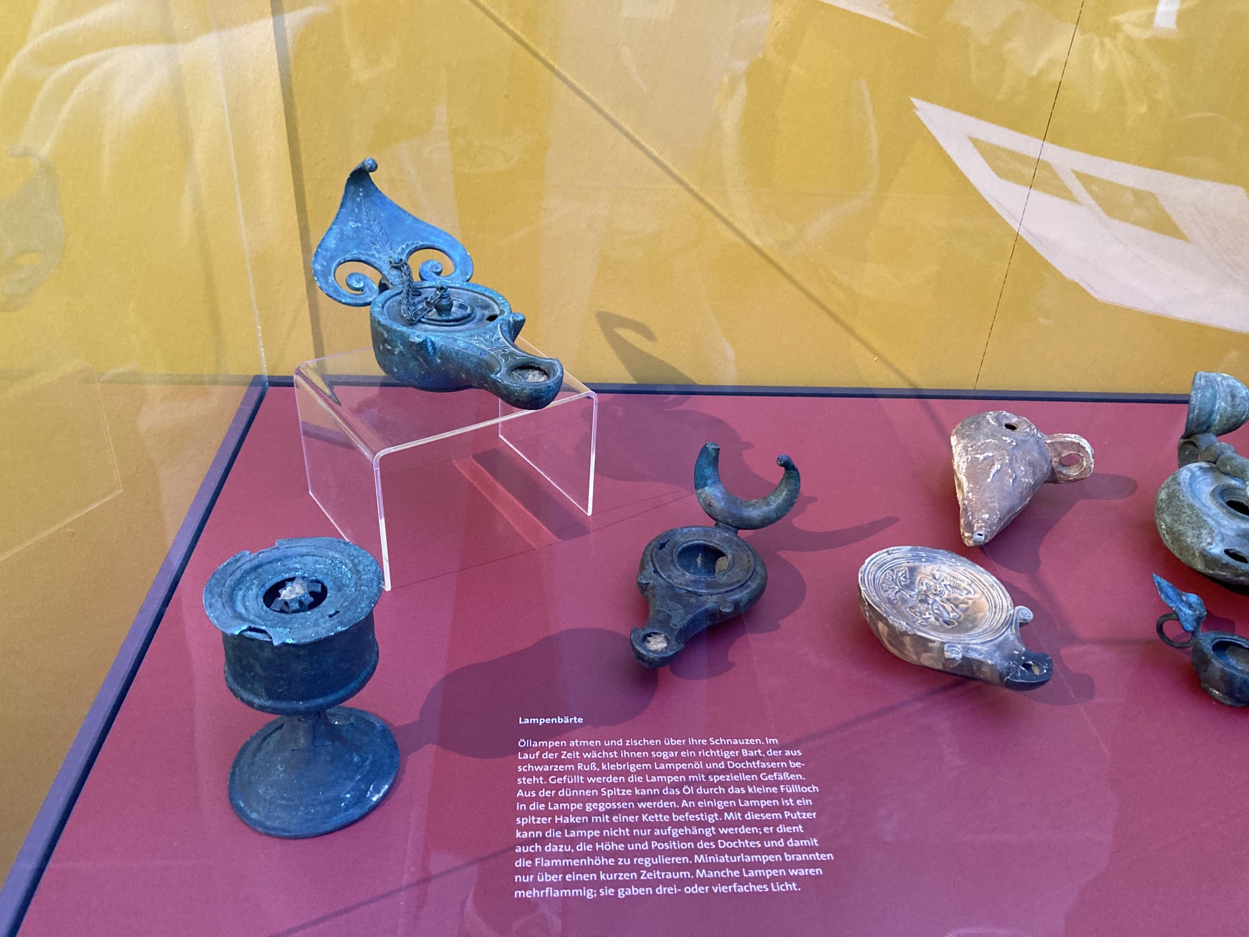 Blick in eine Ausstellungsvitrine;: Öllampen mit originalen Dochten. Ausstellung "Neues Licht in Pompeji / Staatliche Antikensammlungen